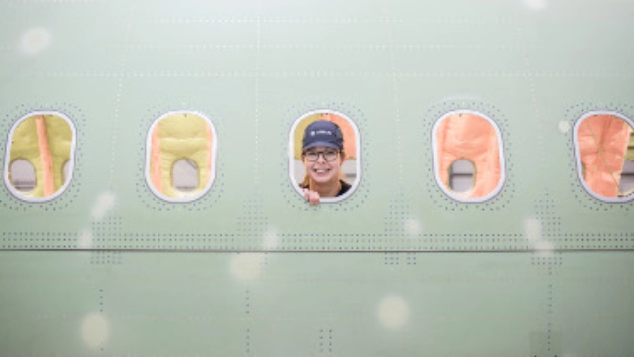 Eine Frau schaut durch das Fenster eines Flugzeugs.