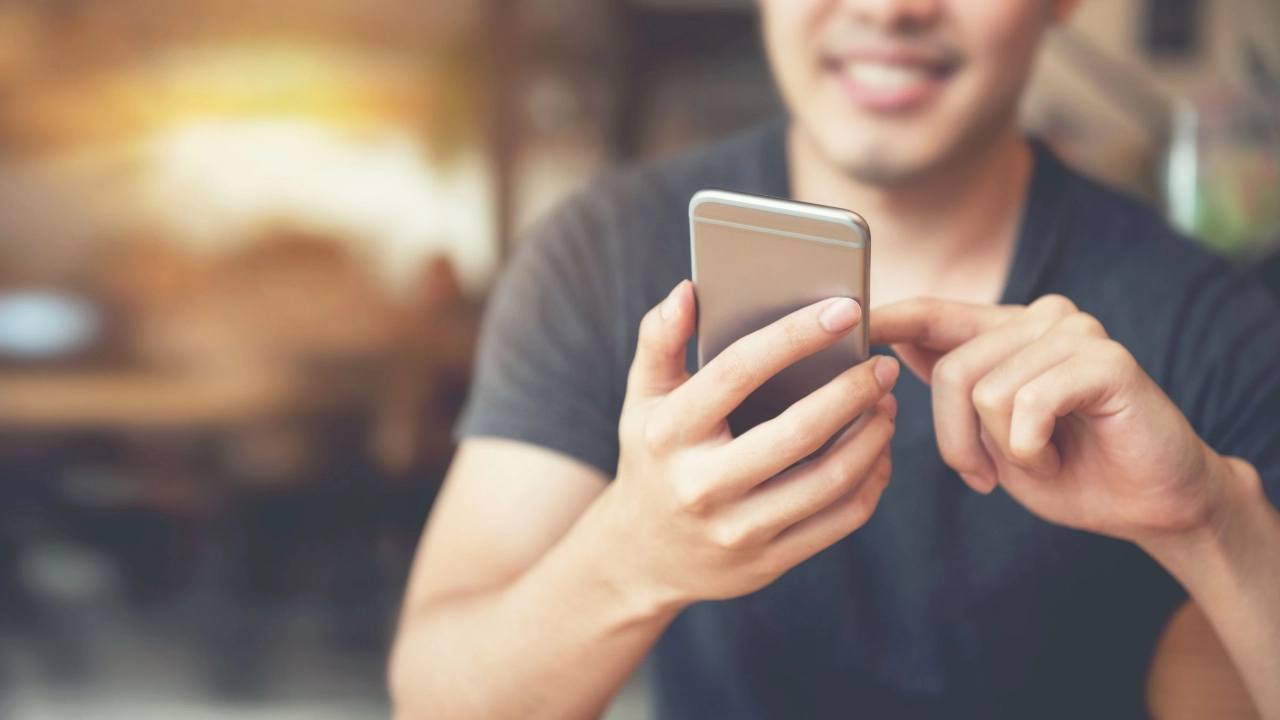 junger Mann bedient ein Smartphone