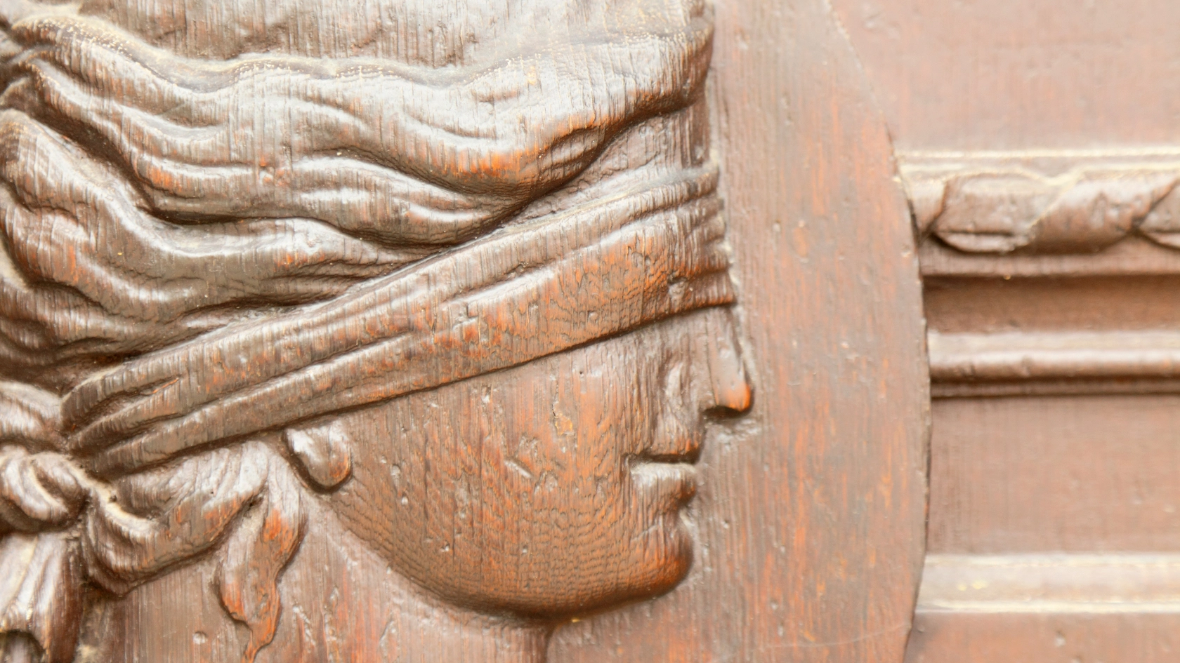 Ein altes Wandrelief von Justizia mit verbundenen Augen
