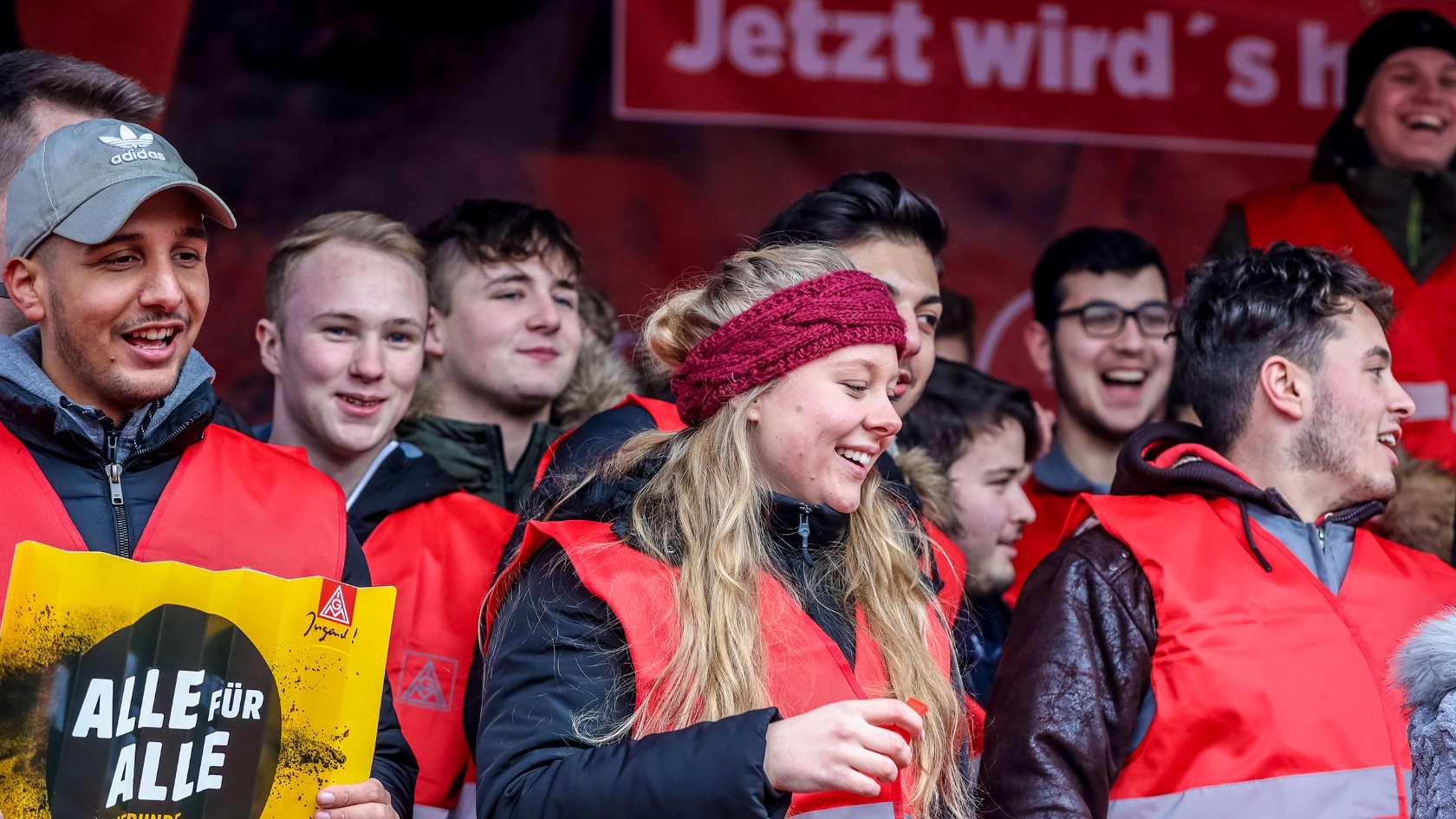 Eine Gruppe Jugendliche mit roten IG Metall-Westen. 