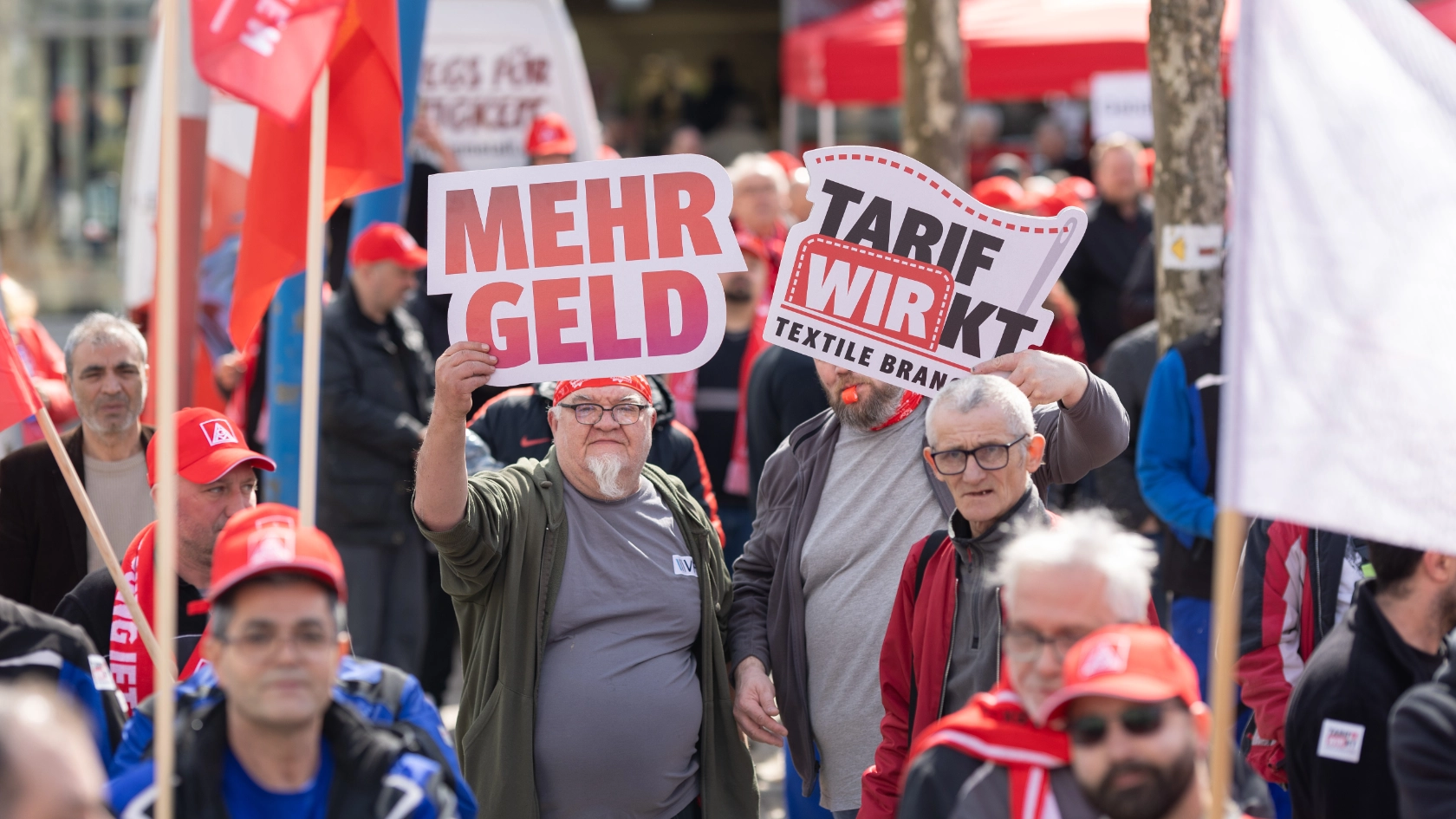 Beschäftigte bei Aktionstag in Heidenheim halten Plakate Tarifrunde Textil- und Bekleidungsindustrie West