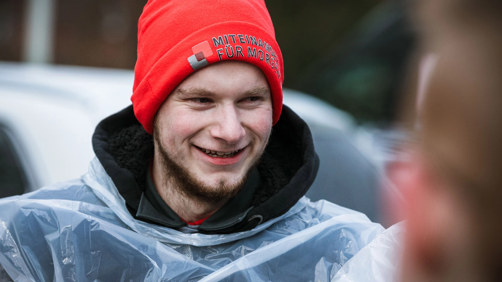 Junger Mann mit roter IG Metall-Mütze