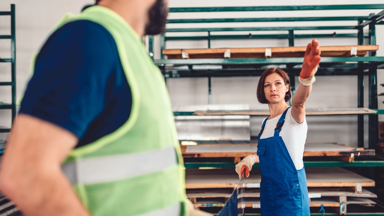 Arbeiterin mit Kollege in einem Metalllager