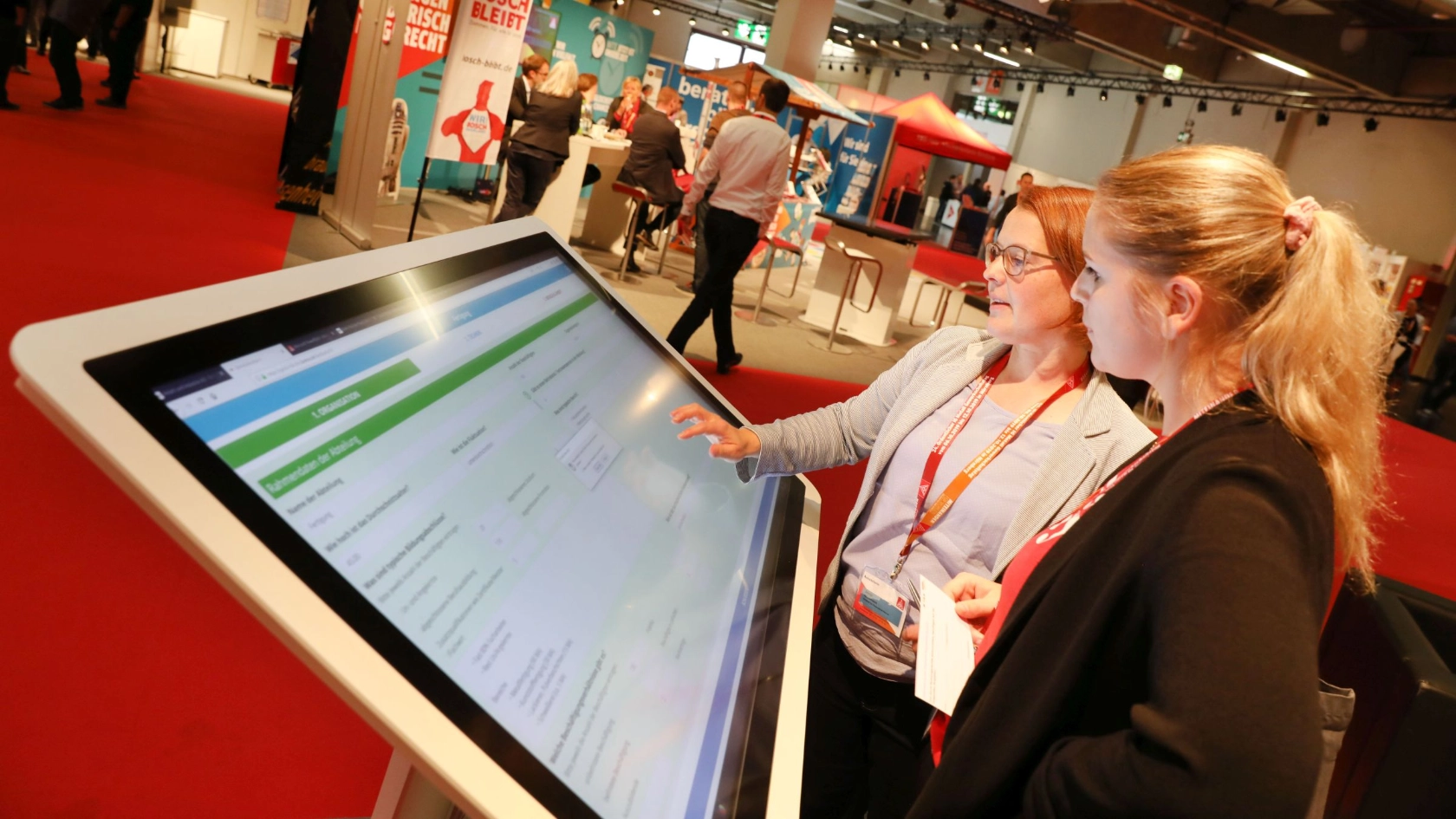 Zwei Delegierte bei der Bedienung eines Touch-Bildschirms auf dem Gewerkschaftstag 2019 der IG Metall