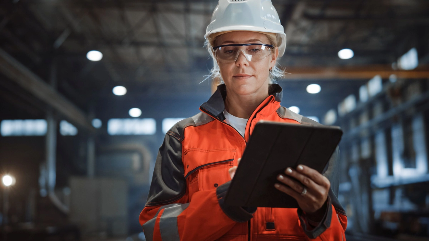Arbeiterin mit Helm und Tablet