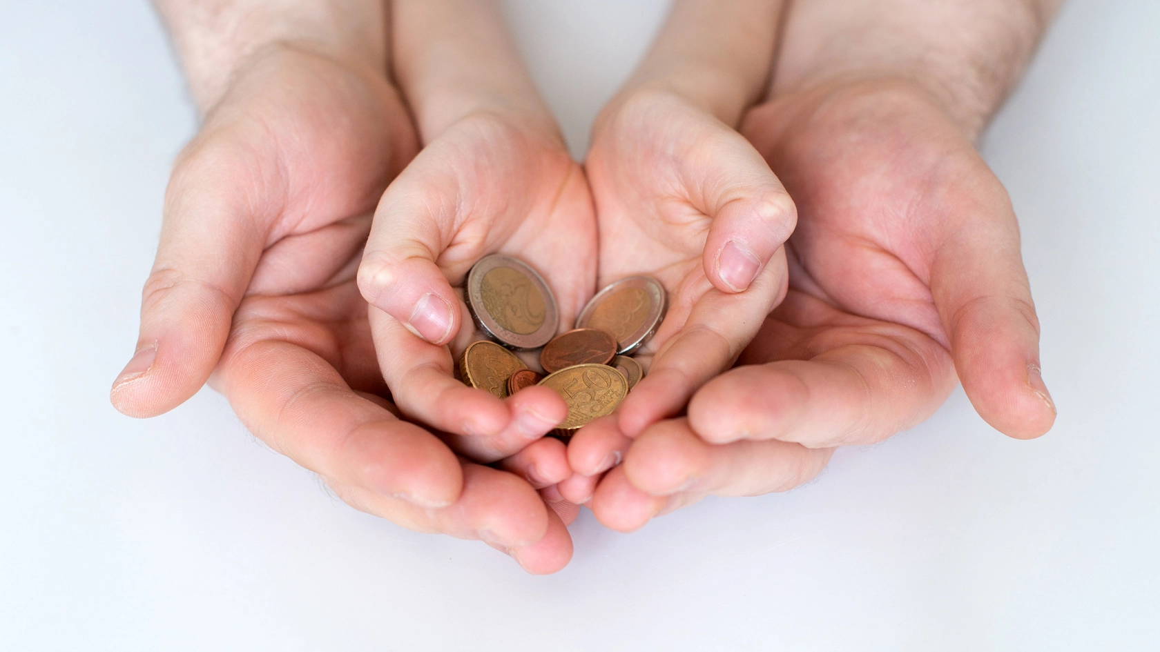 Vater und seiner Kind halten Euro-Münzen in den Händen