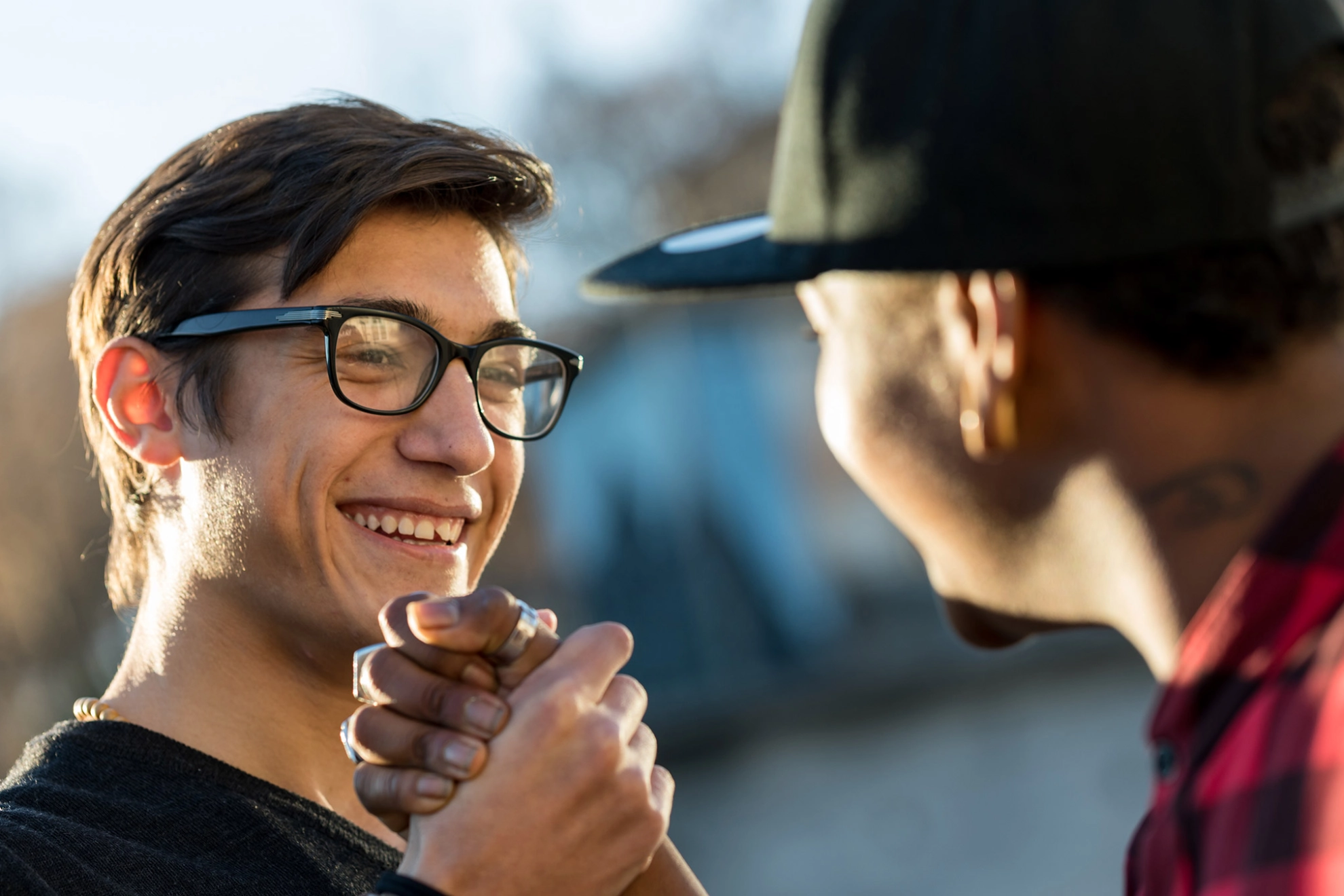 Zwei junge Männer geben sich lächelnd die Hand