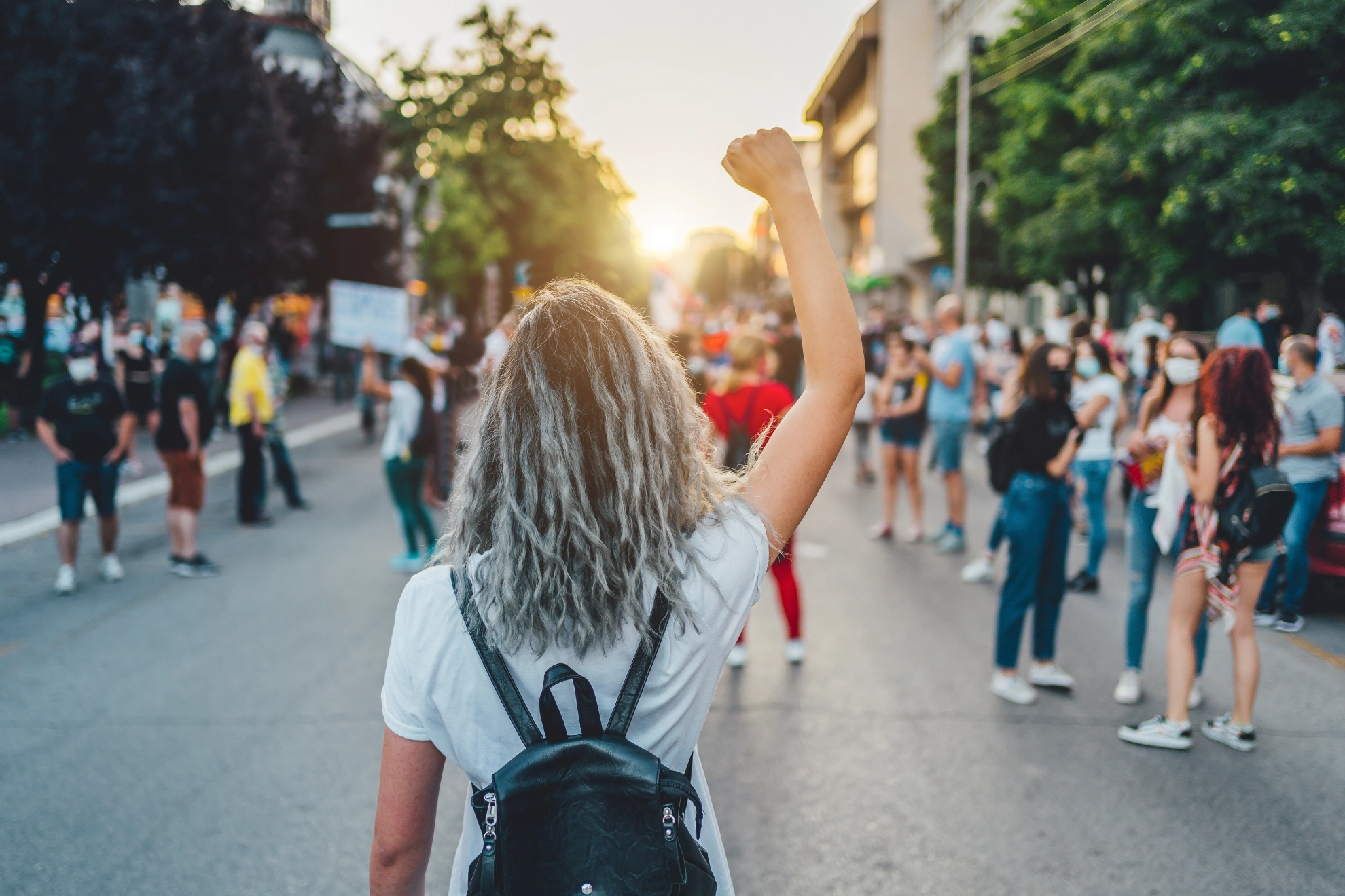 Frau mit erhobener Faust protestiert auf der Straße.
