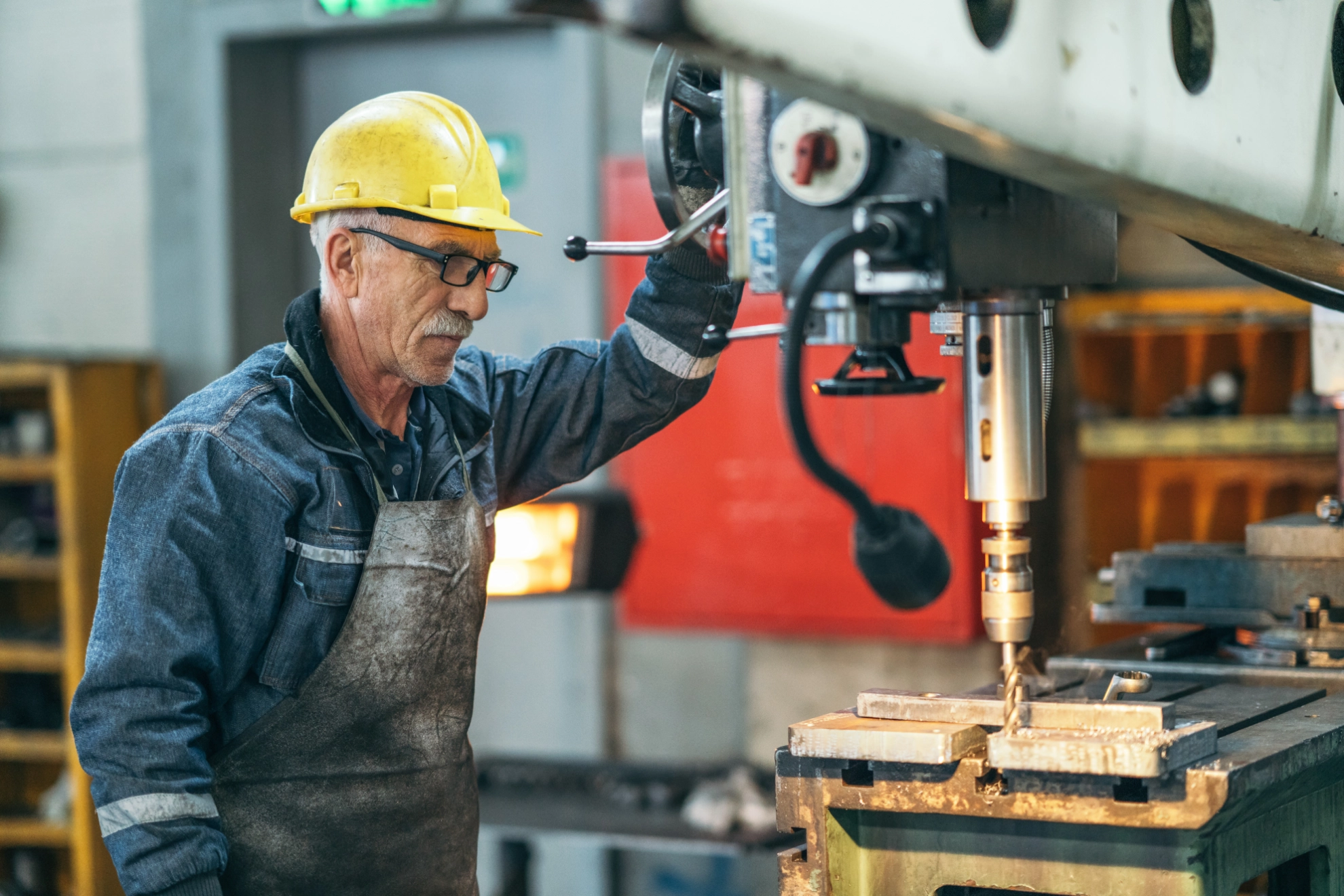 Arbeiter in einer Werkstatt an einer Bohrmaschine