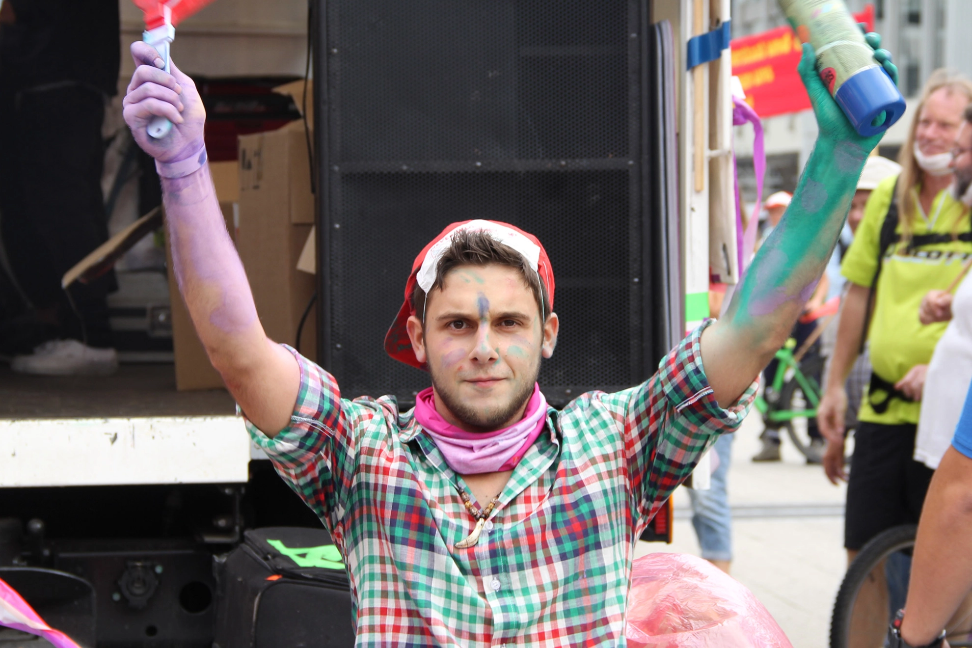 Junger Mann hat Spraydosen in der Hand und ist auf einer Demo.