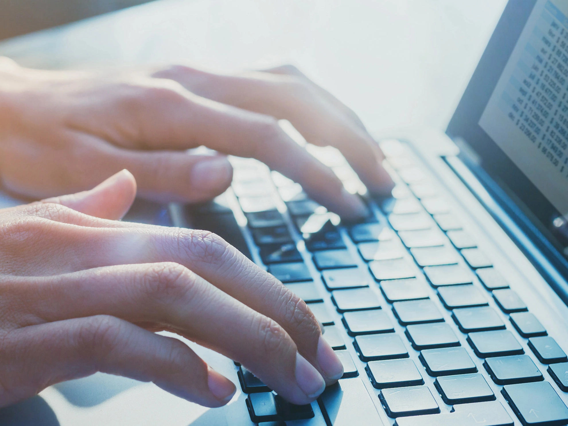 Mensch schreibt an einem Laptop