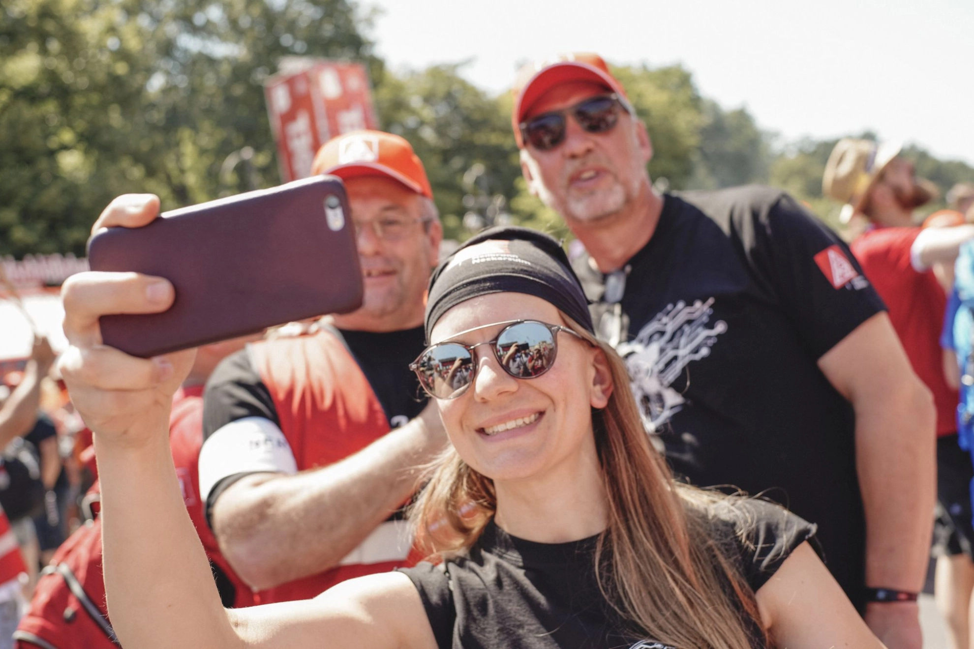 Metallerin schießt mit zwei Metallern ein Selfie-Foto auf der FairWandel-Kundgebung