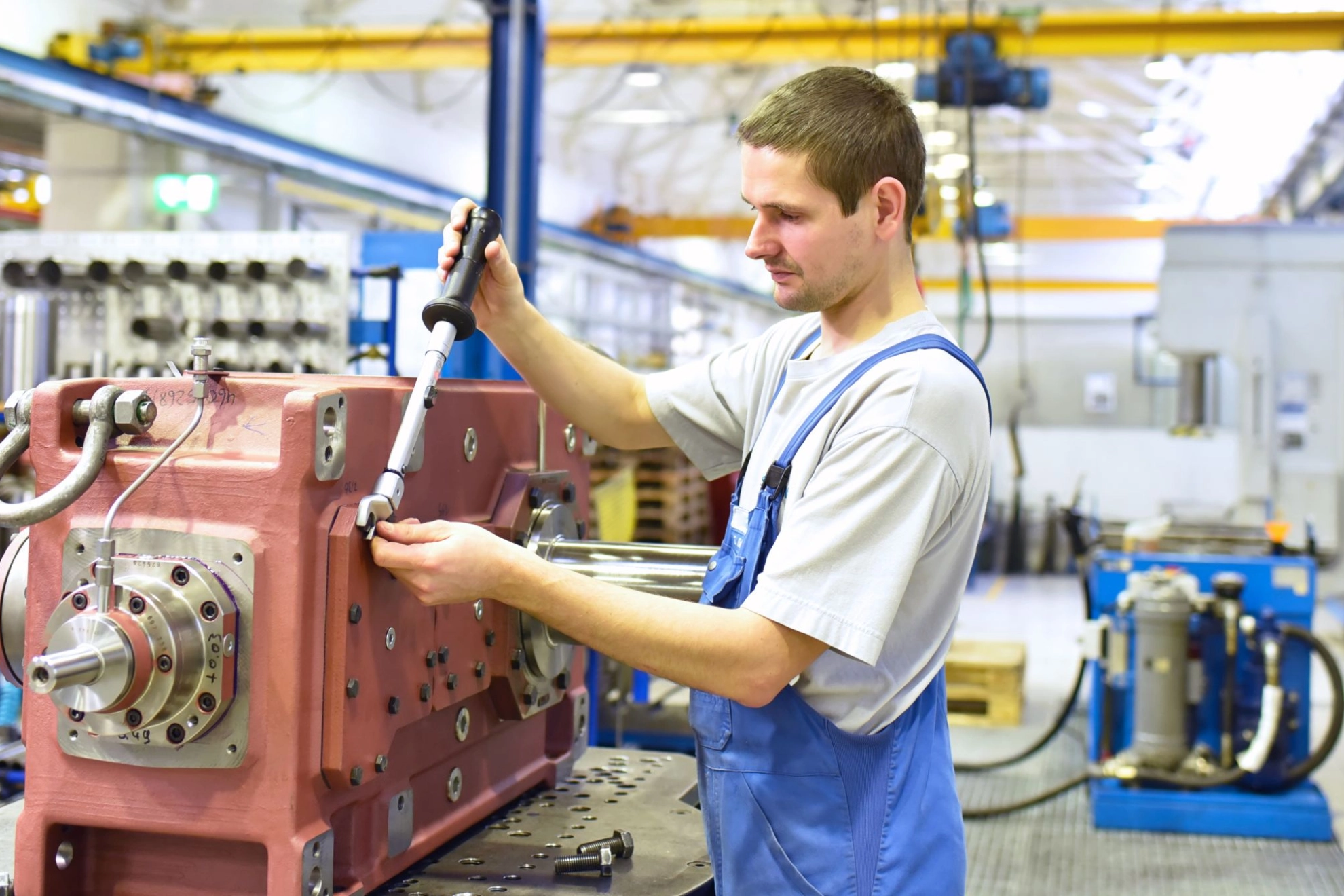 Beschäftigter arbeitet an einem Getriebe in einer Fabrik