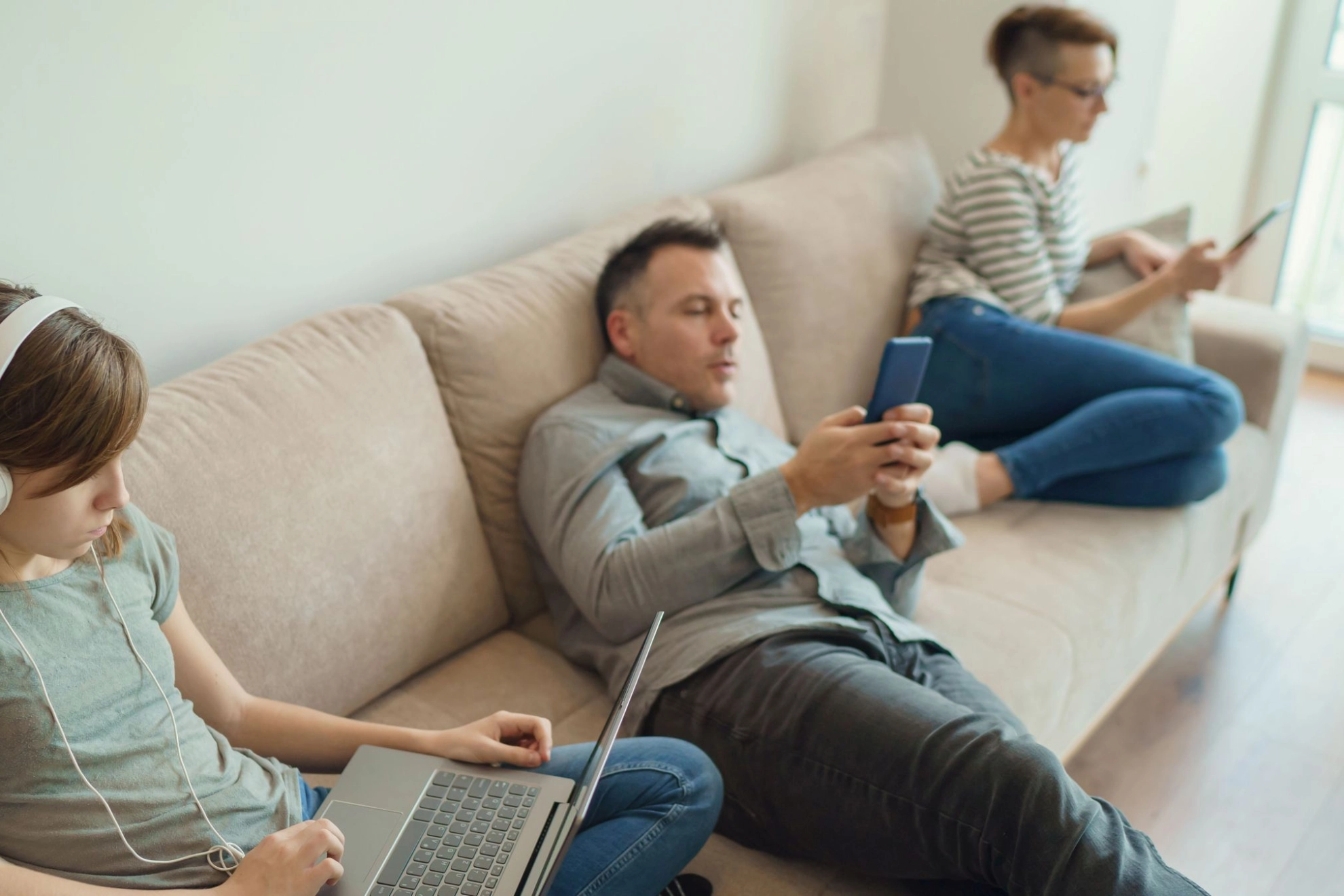 Familie sitzt gelangweilt auf dem Sofa
