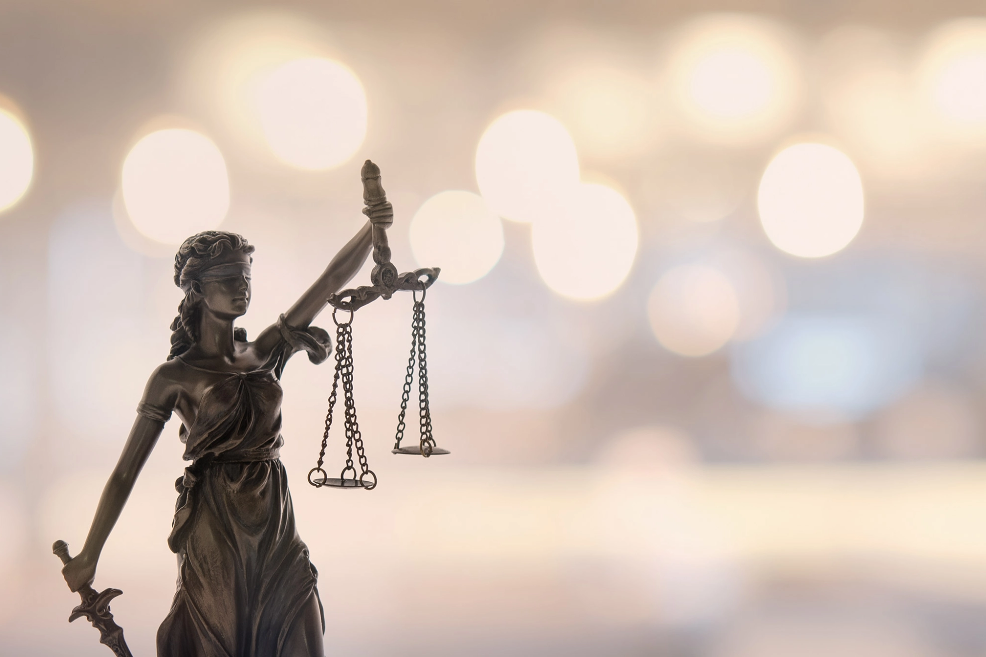 Justitia, die Göttin der Gerechtigkeit vor unscharfen Hintergrund