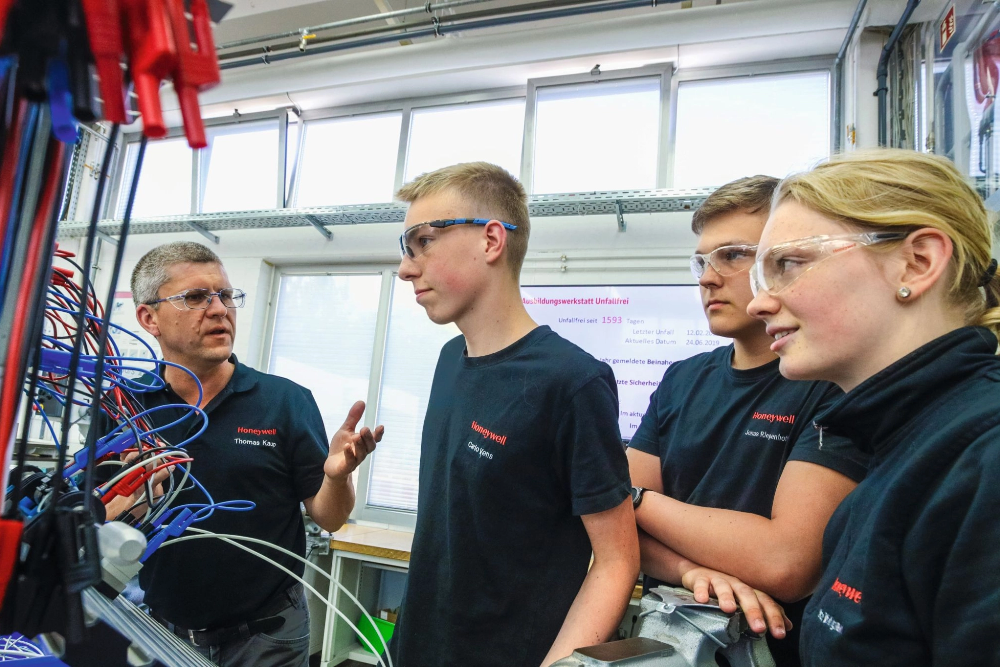 junge Auszubildende lernen eine Roboteranlage zu bedienen
