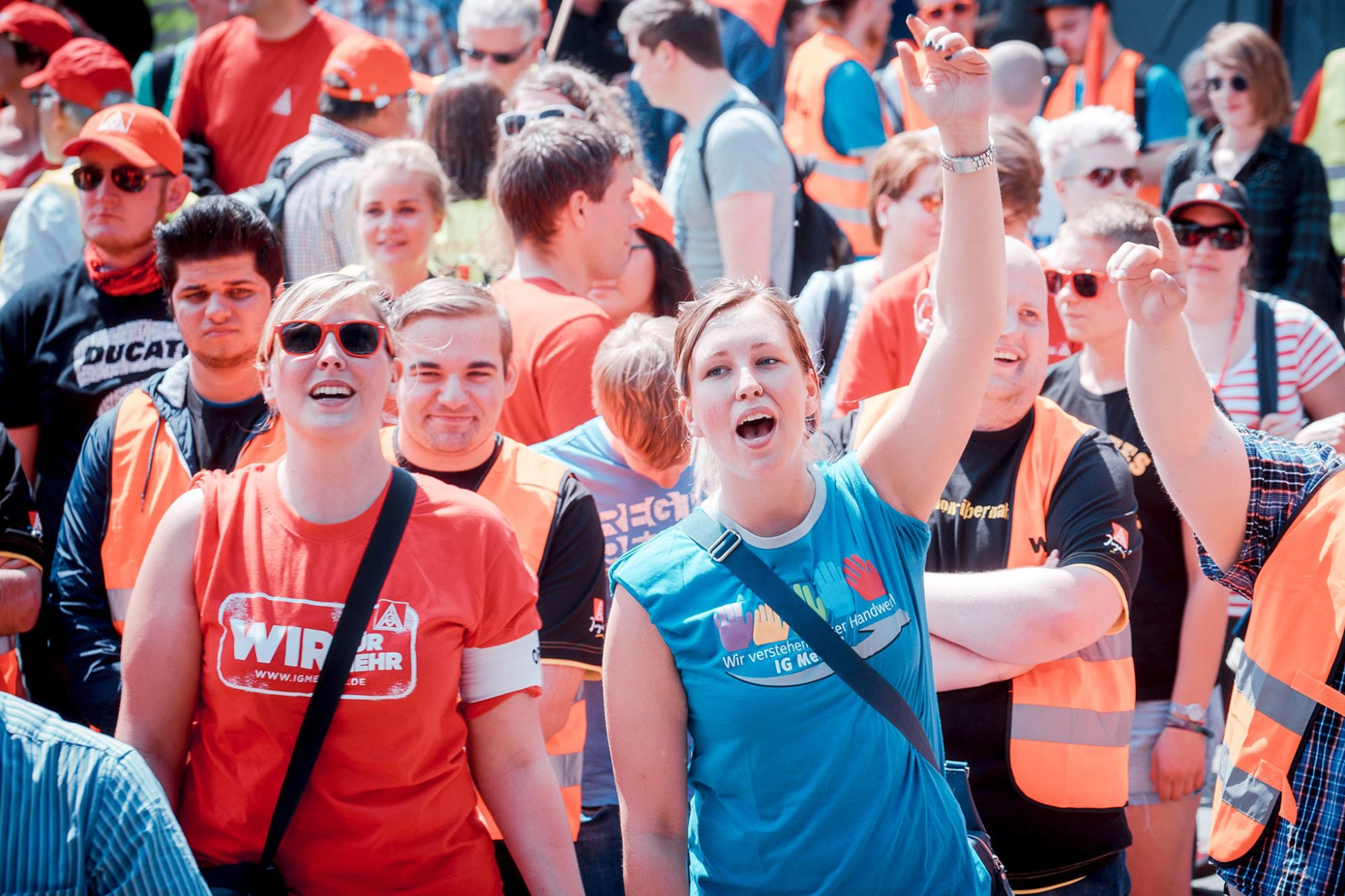 In Mitten einer größeren Menge recken zwei junge Menschen während einer Demonstration die Hände in die Luft.