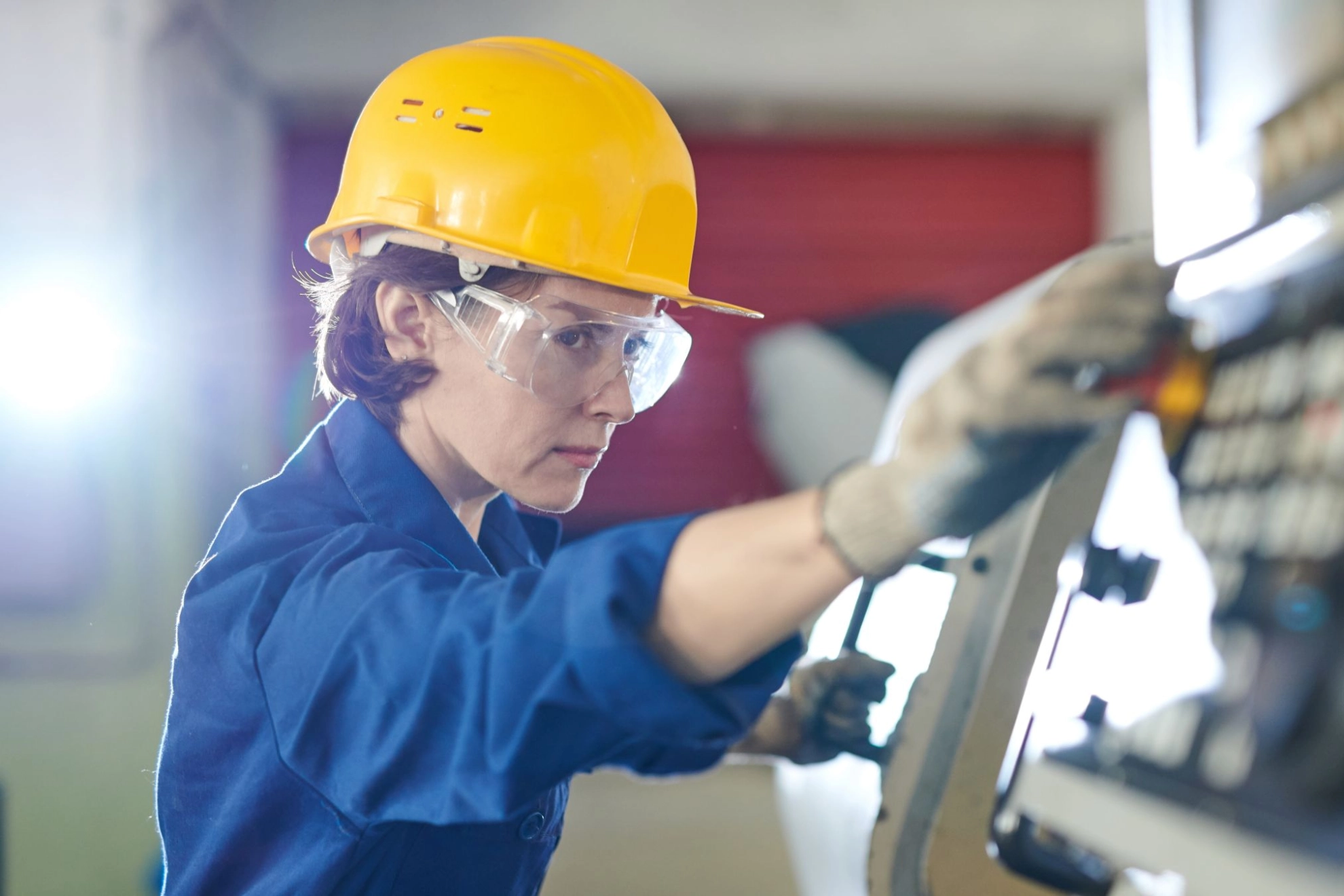 Arbeitnehmerin bedient Industriemaschine