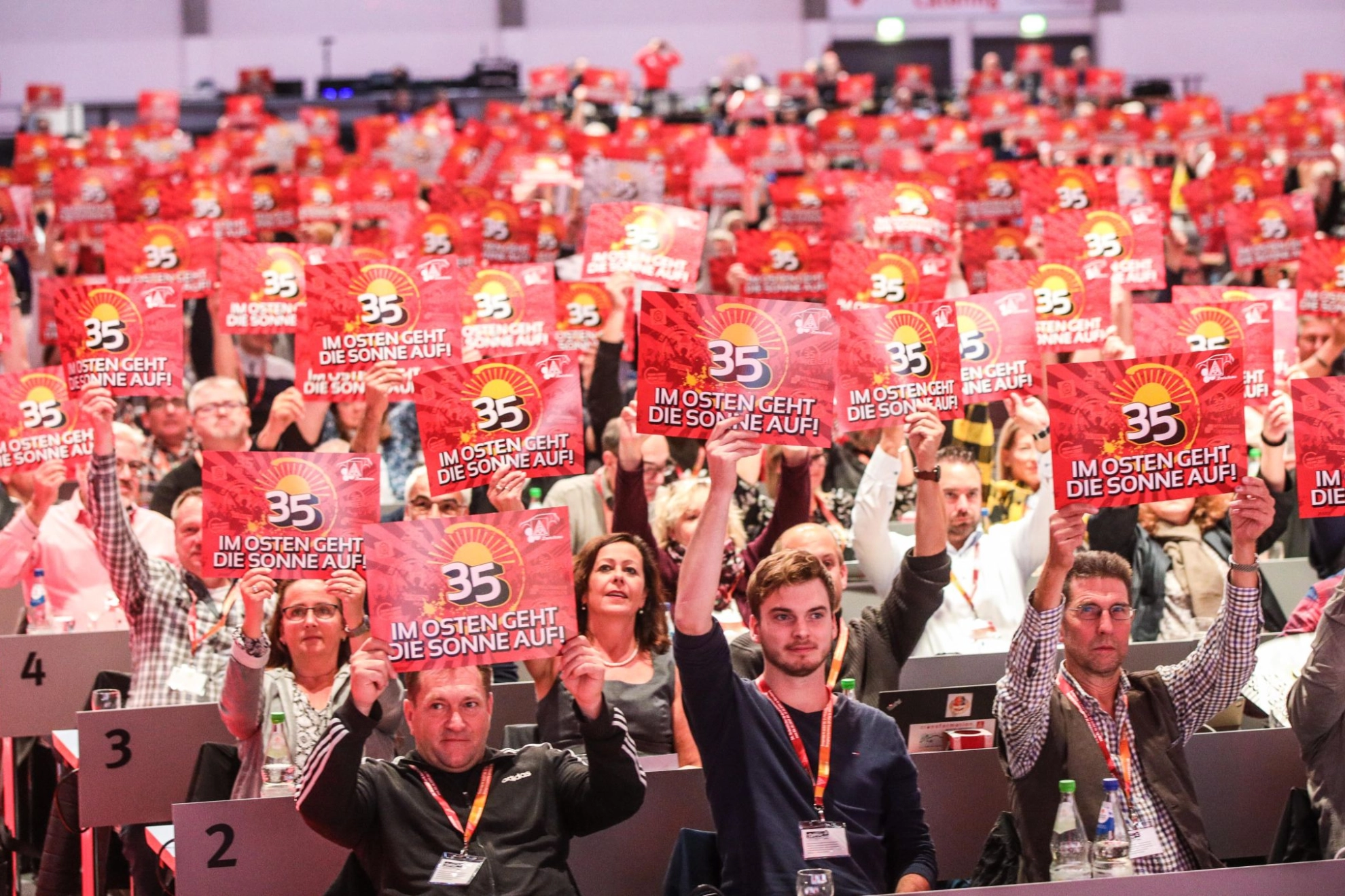Delegierte auf dem Gewerkschaftstag 2019 der IG Metall halten Schilder für die 35-Stunden-Woche im Osten hoch
