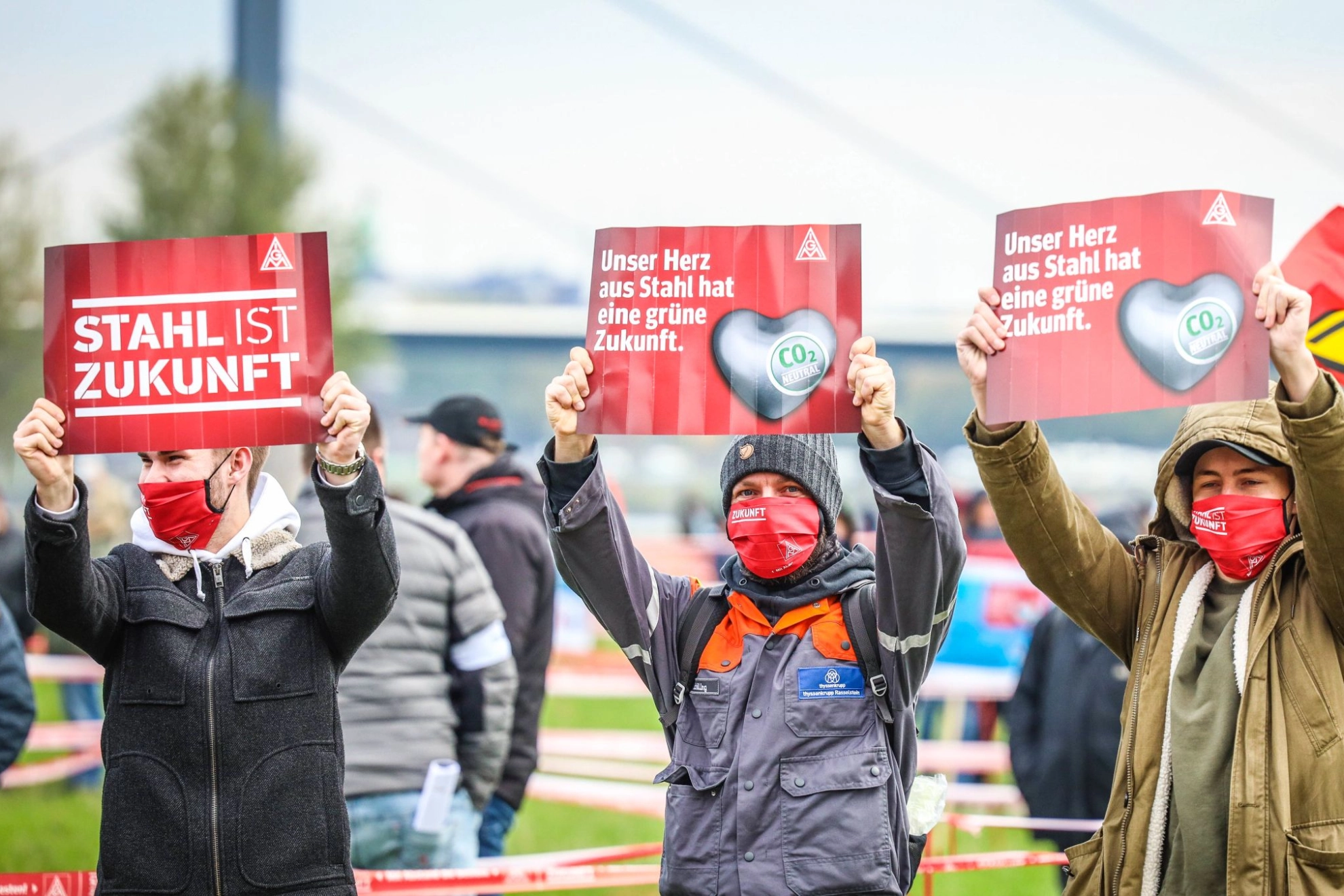 Teilnehmer einer Demo die Plakate mit dem Titel „Stahl ist Zukunft“ hochhalten