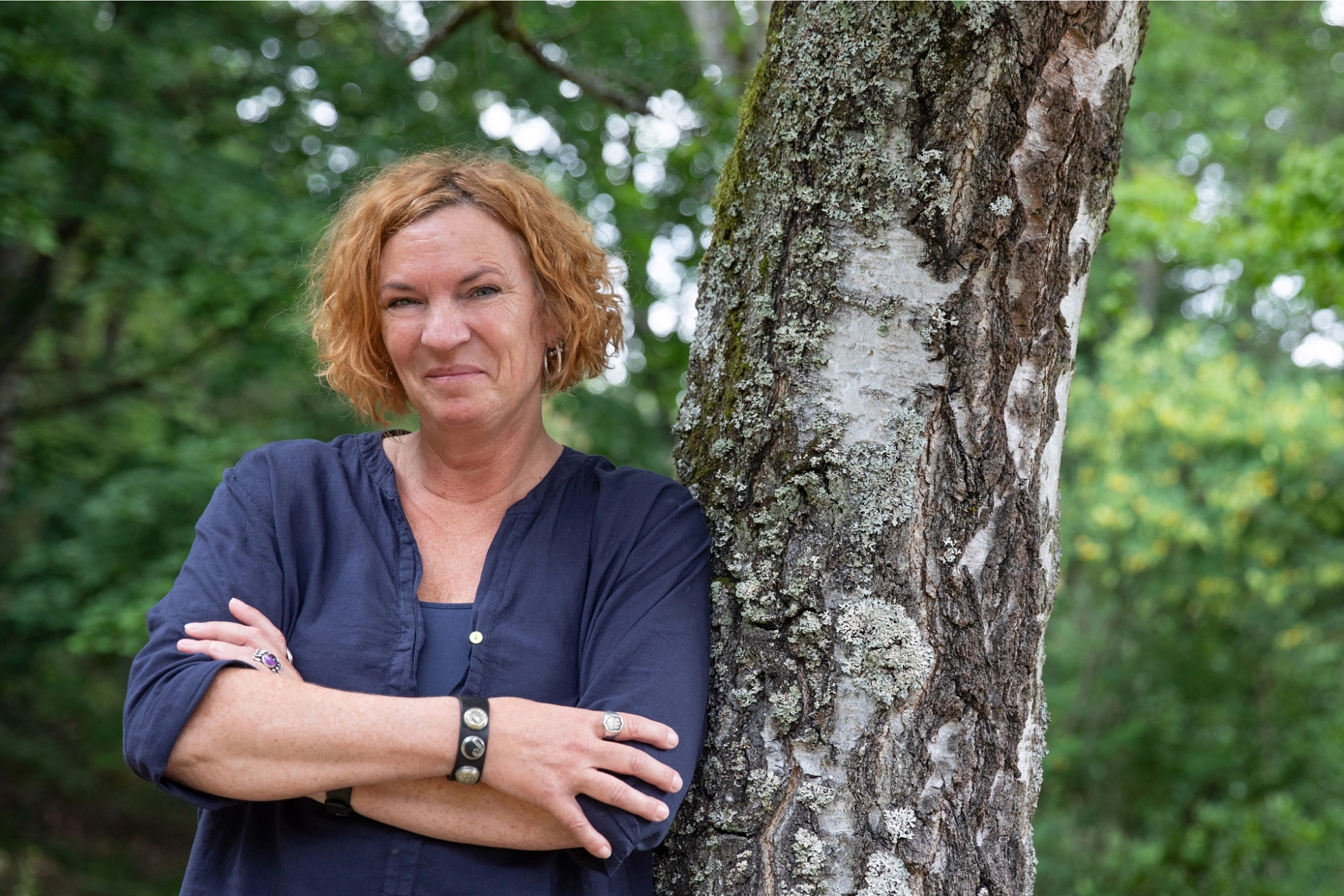 Resolute Frau lehnt am Baum