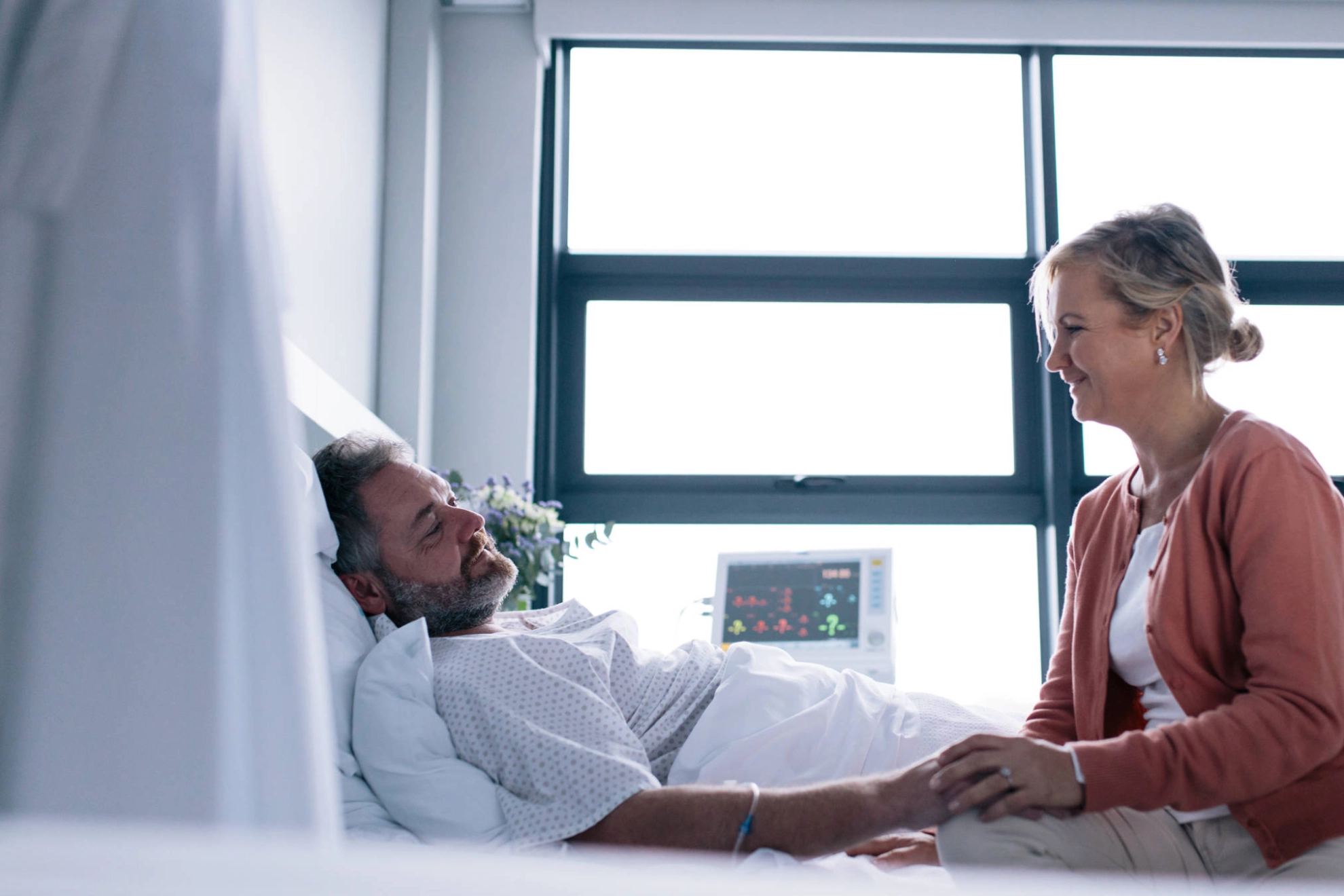 Eine Frau besucht einen Mann im Krankenhaus. 