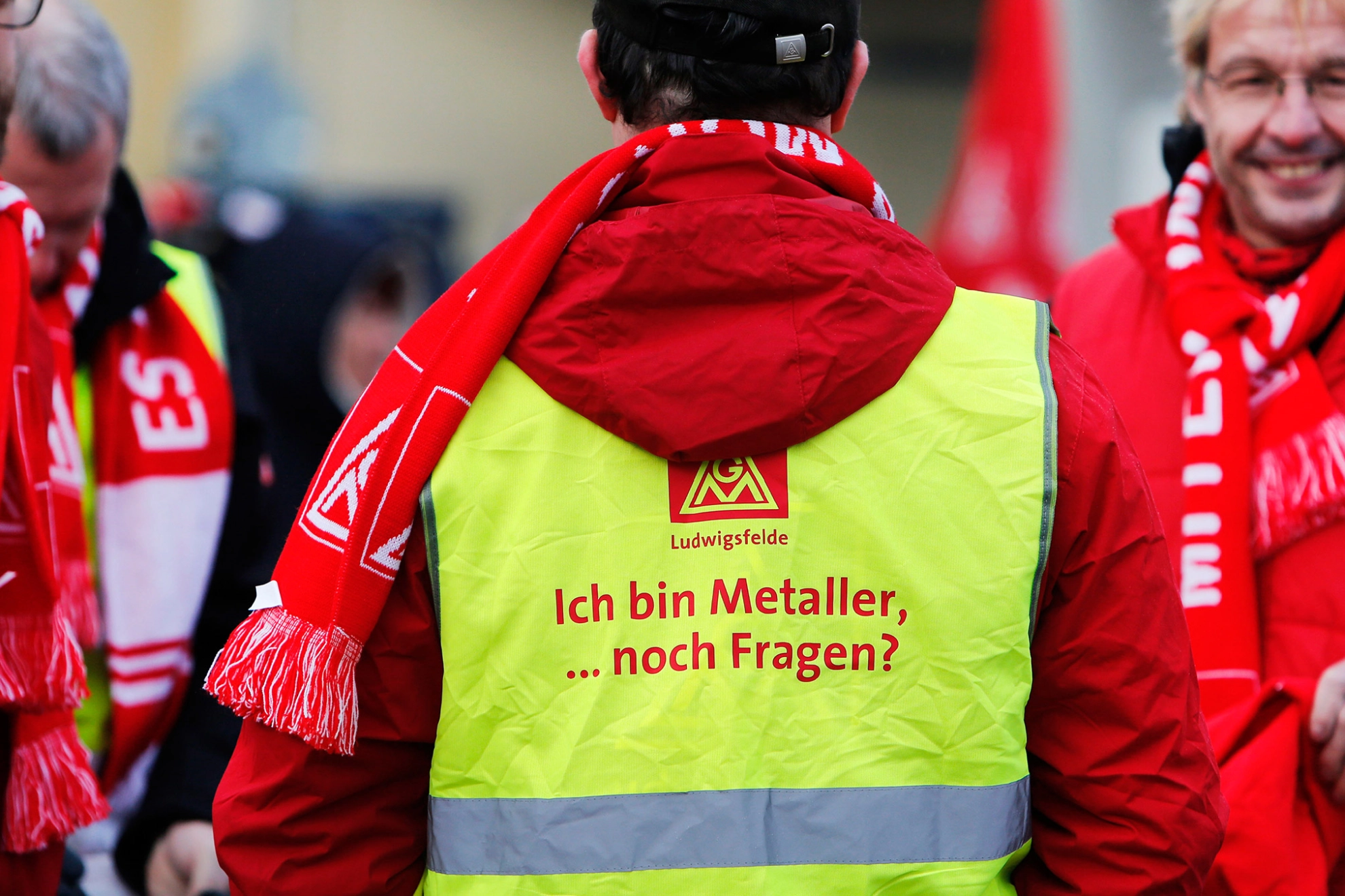 Ein Mann mit einer gelben Weste auf der "Ich bin Metaller, noch Fragen?" steht.