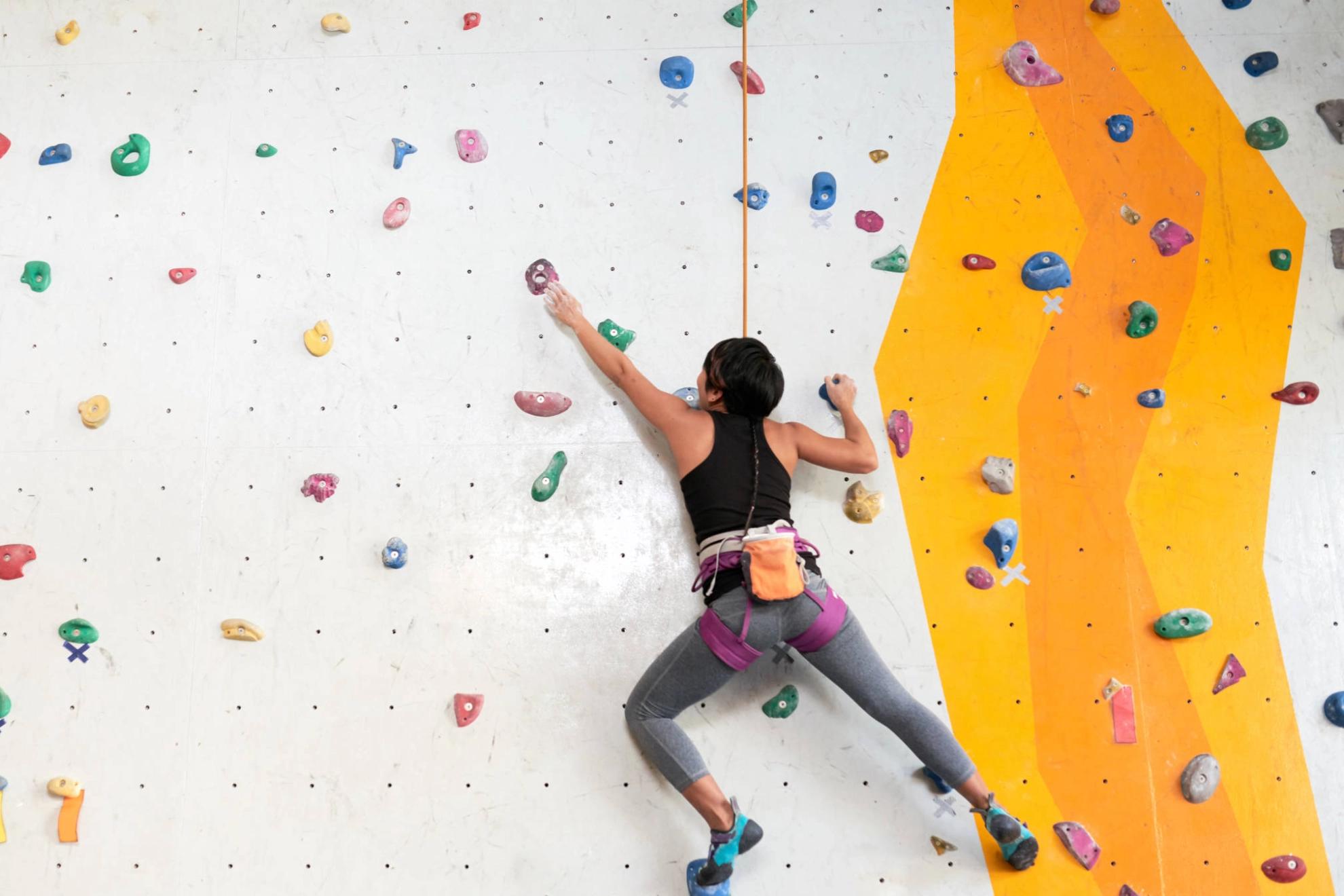 Eine Frau an einer Kletterwand.