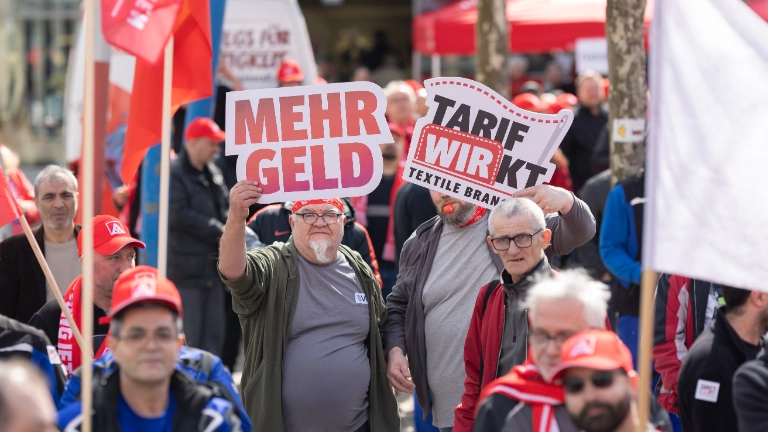 Beschäftigte bei Aktionstag in Heidenheim halten Plakate Tarifrunde Textil- und Bekleidungsindustrie West